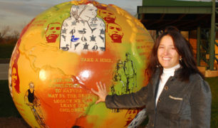 Nancy and her globe with the Green Cultural Center in the background.