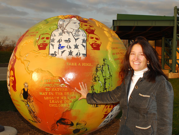 Nancy and her globe with the Green Cultural Center in the background.