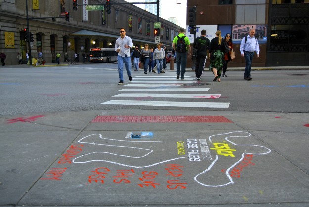 Commuters pass a chalk badge near Ogilvie Transportation Center