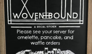 Chalkboard with text "Please see your server for omelette, pancake, and waffle orders" and image of shelf of books