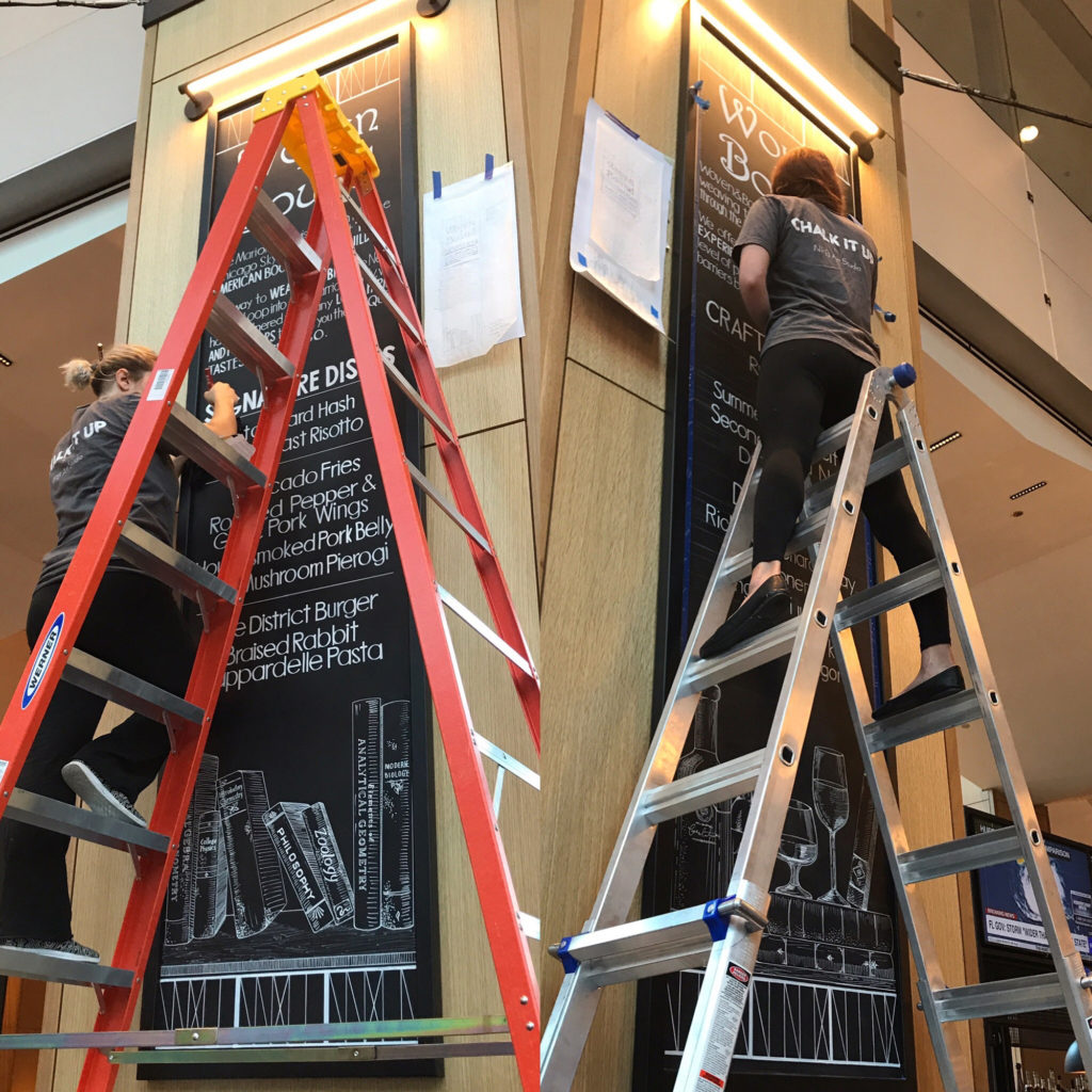 NPB Studio artists on ladders creating chalk boards for Woven + Bound